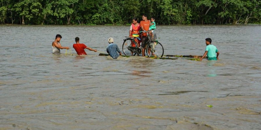 Villagers on a banana raft move to a safer place from the flooded area of Goalbil in Baksa district of Assam. (Photo | PTI)